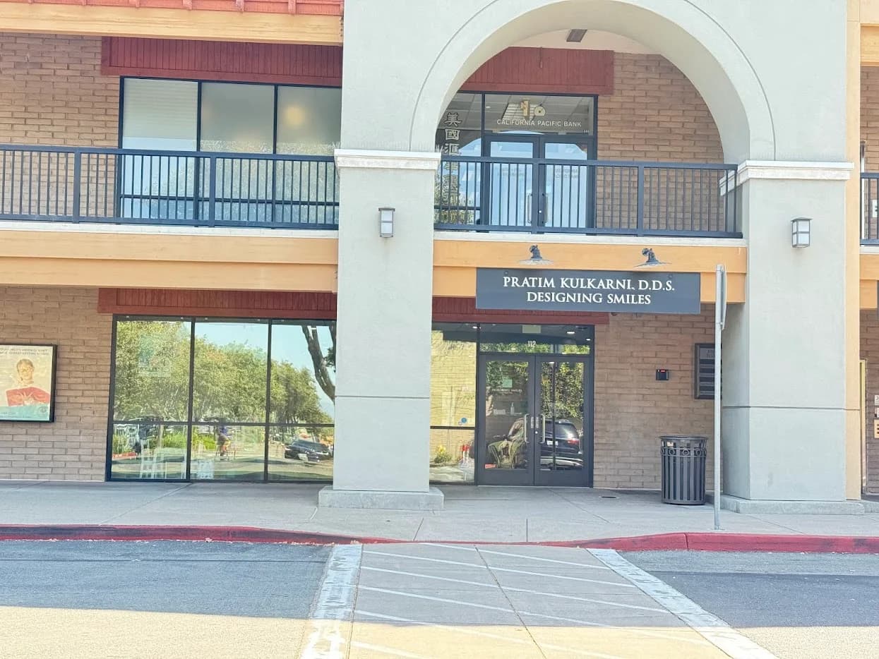 Designing Smiles office entrance with glass door and signage